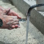 Hands being washed with soap and water regular vs antibacterial soap discussion.