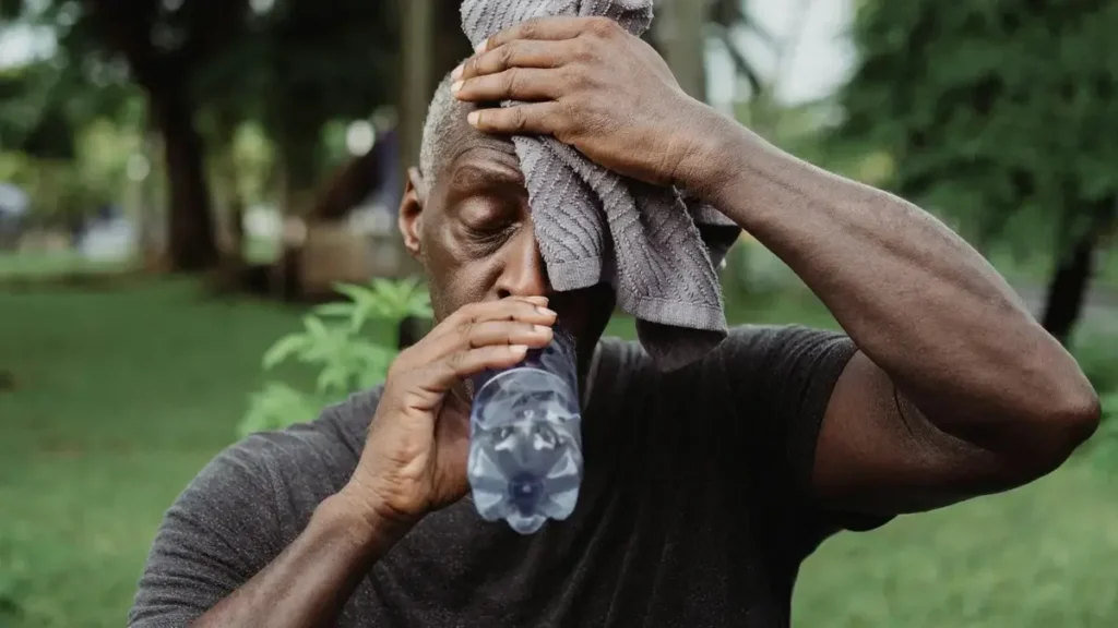 Glass of water next to a stethoscope, on a light surface symbolising hydration and heart health.
