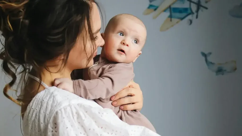 Parent gently patting a newborn’s back baby receives soft touch.
