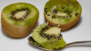 A few fresh kiwifruits showing whole fruit and cut‑open ones.
