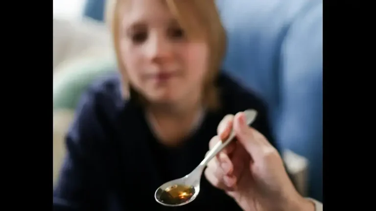 Bottle of syrup and children’s medicine spoon highlighting concerns about misuse of liquid painkiller for kids.