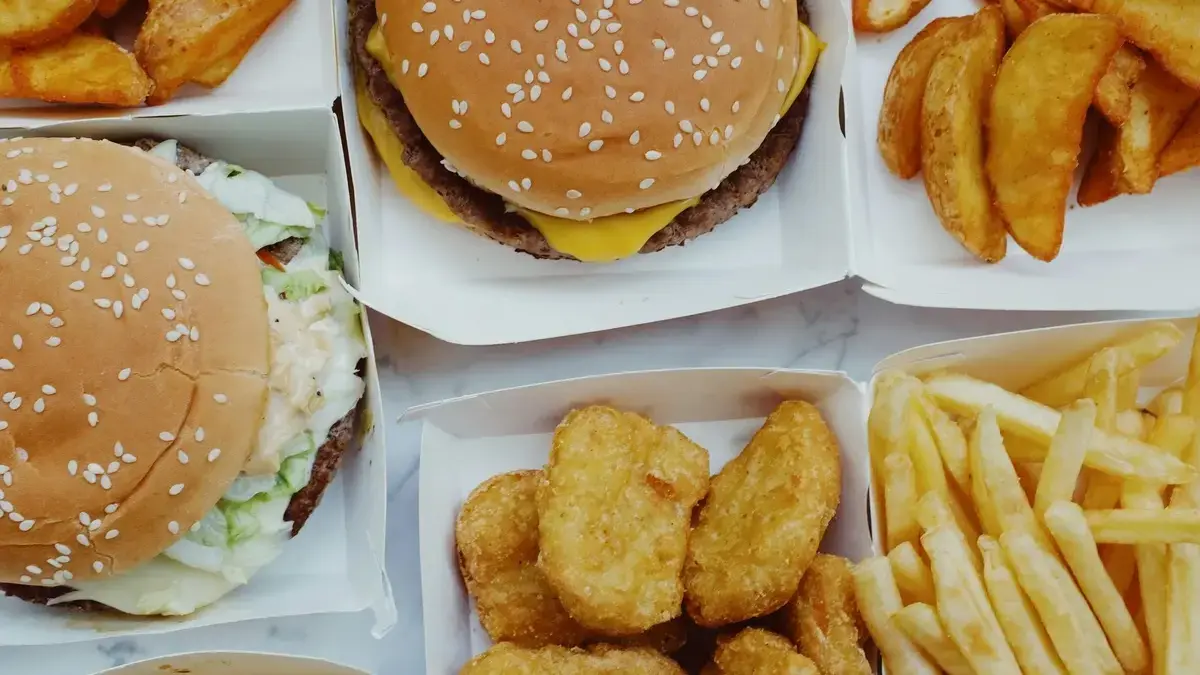 Assorted processed foods (snacks, packaged meals, soda) next to a brain icon — implying processed food may harm brain health.