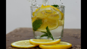 Fresh lemons whole and sliced, on a kitchen surface.