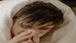 Cup of herbal tea with ginger and honey on wooden table for cold and flu relief