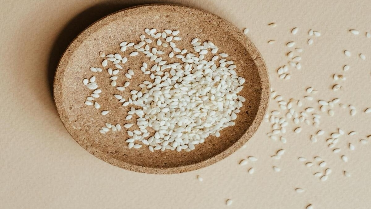 Black and white sesame seeds with a bone icon, showing their benefits for bone health.