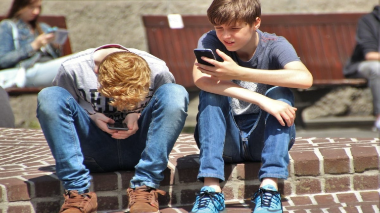 Teen using social media with stressed expression, highlighting mental health impact.