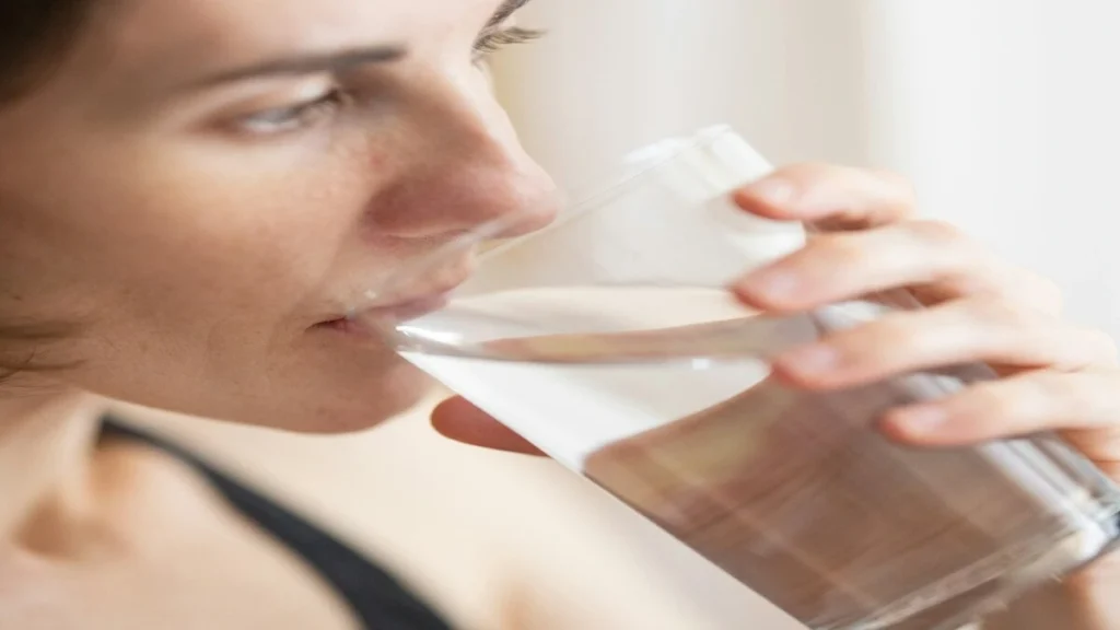Person drinking warm water for digestive comfort and hydration