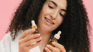 Rosemary essential oil bottle with fresh rosemary leaves for hair regrowth and scalp health