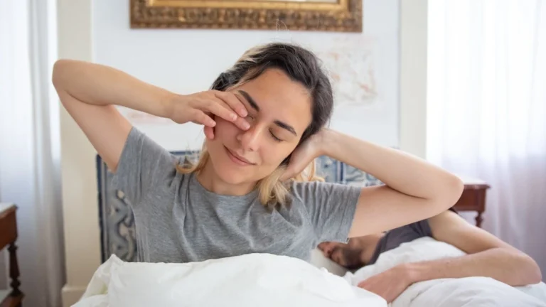 Man sitting on bed after waking up slowly to support heart health after 40