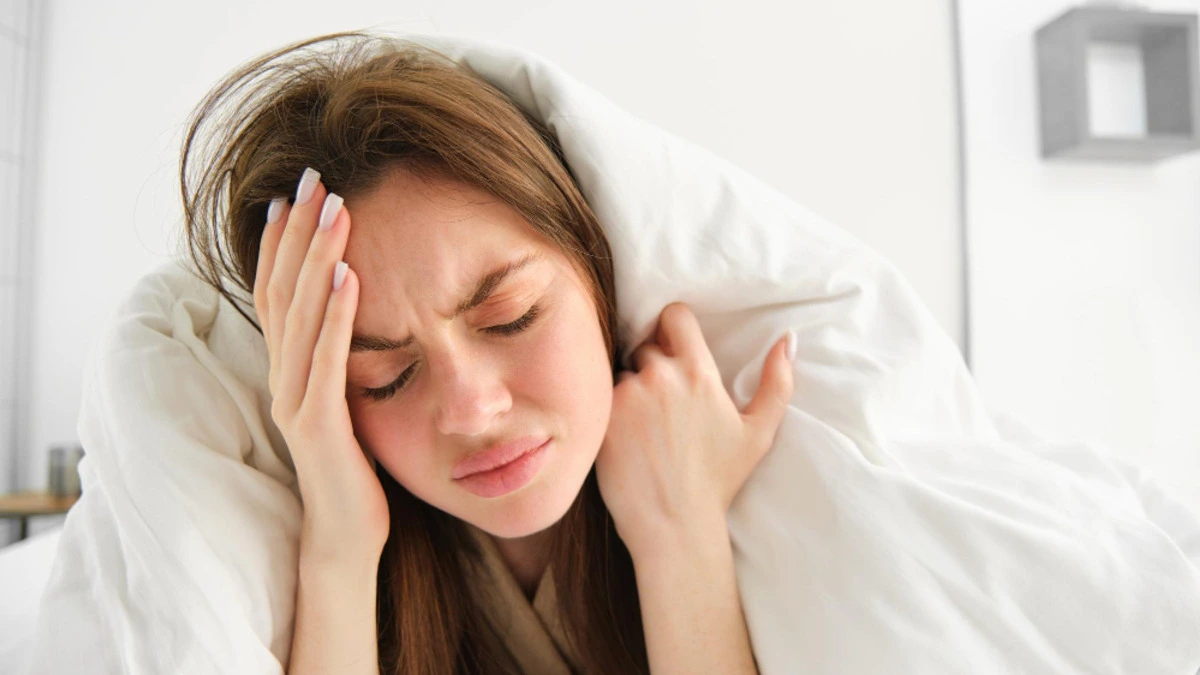 Woman lying awake in bed struggling with insomnia at night