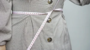 Weight loss supplements concept with measuring tape, healthy food and fitness background