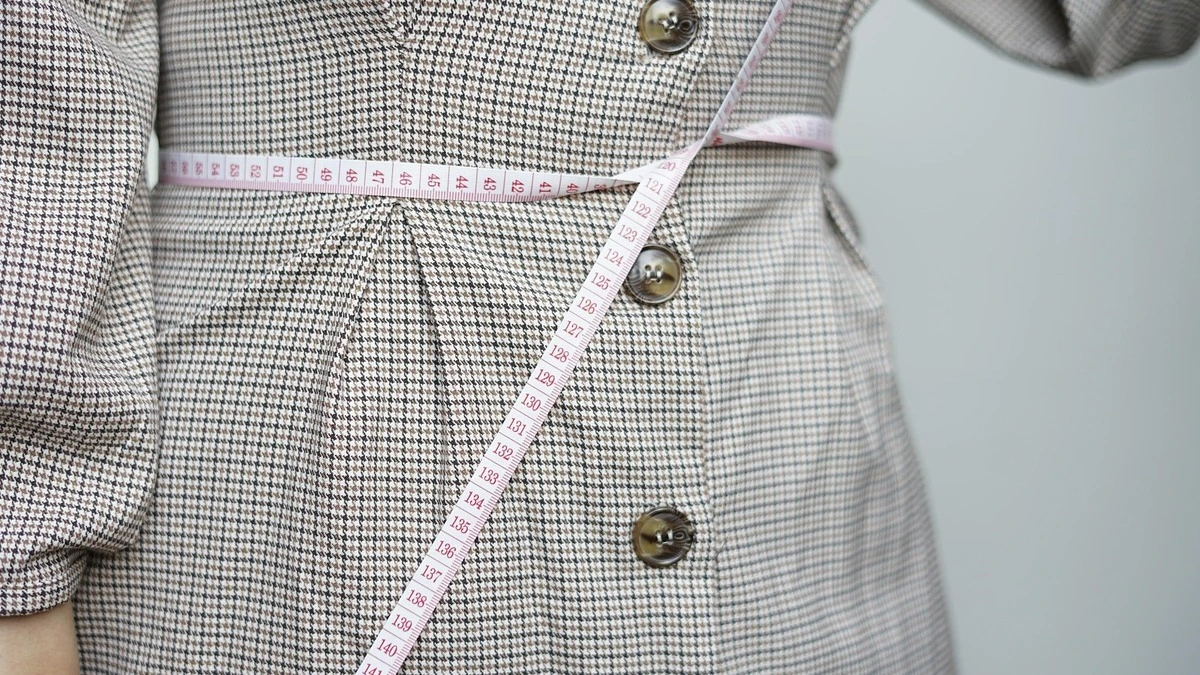 Weight loss supplements concept with measuring tape, healthy food and fitness background