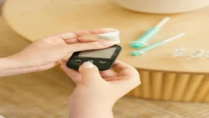 Person checking blood sugar level with glucometer showing normal HbA1c concept