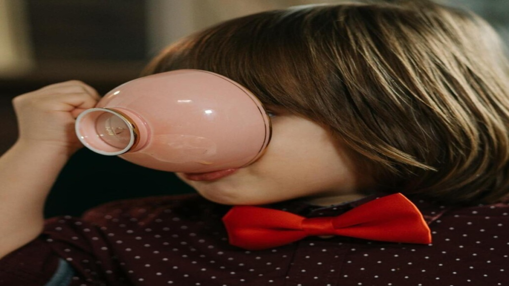 Mother caring for a baby while holding a warm drink, representing tea safety concerns for infants and toddlers
