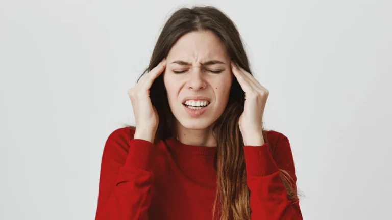 Person suffering from a migraine while using painkillers, illustrating medication overuse headache and rebound headache symptoms.