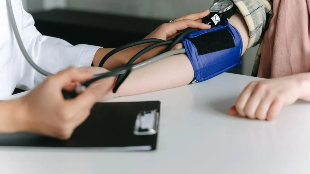 Digital blood pressure monitor showing high systolic and diastolic readings on screen