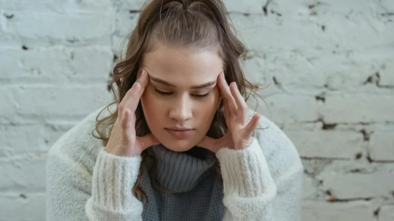 Woman experiencing a migraine with aura while reviewing birth control options, highlighting the connection between hormonal contraception and stroke risk.