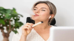Person experiencing anxiety while holding a vape device, illustrating the connection between vaping and mental health.