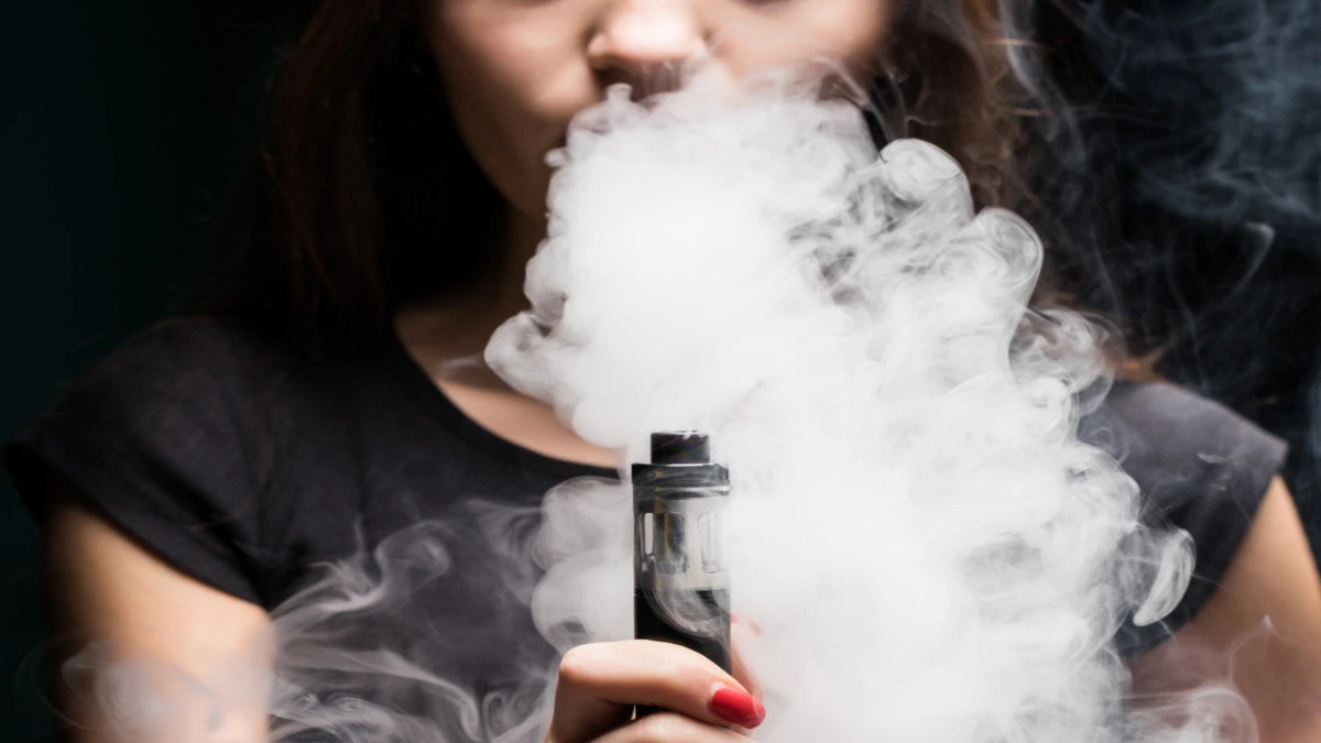 Person using a vape device with highlighted body organs showing vaping health risks
