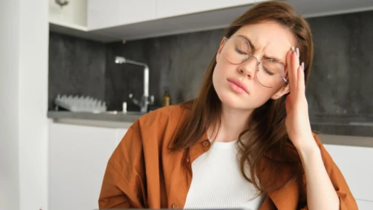 Person holding head in pain showing migraine symptoms, representing headache relief medication comparison.