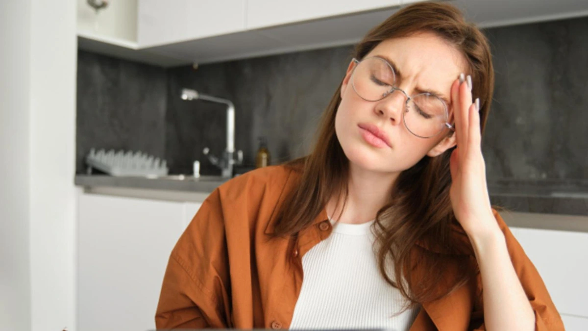 Person holding head in pain showing migraine symptoms, representing headache relief medication comparison.
