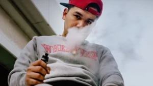 Person vaping with blood pressure monitor in background, vaping and blood pressure concept