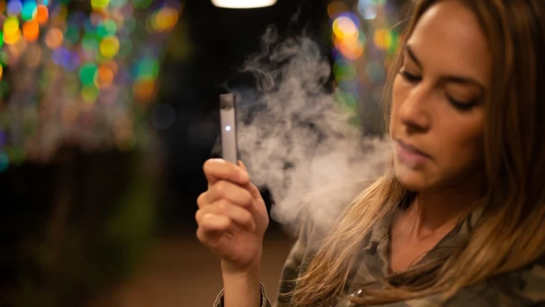 Cigarette and vape device placed side by side showing the comparison between smoking and vaping risks