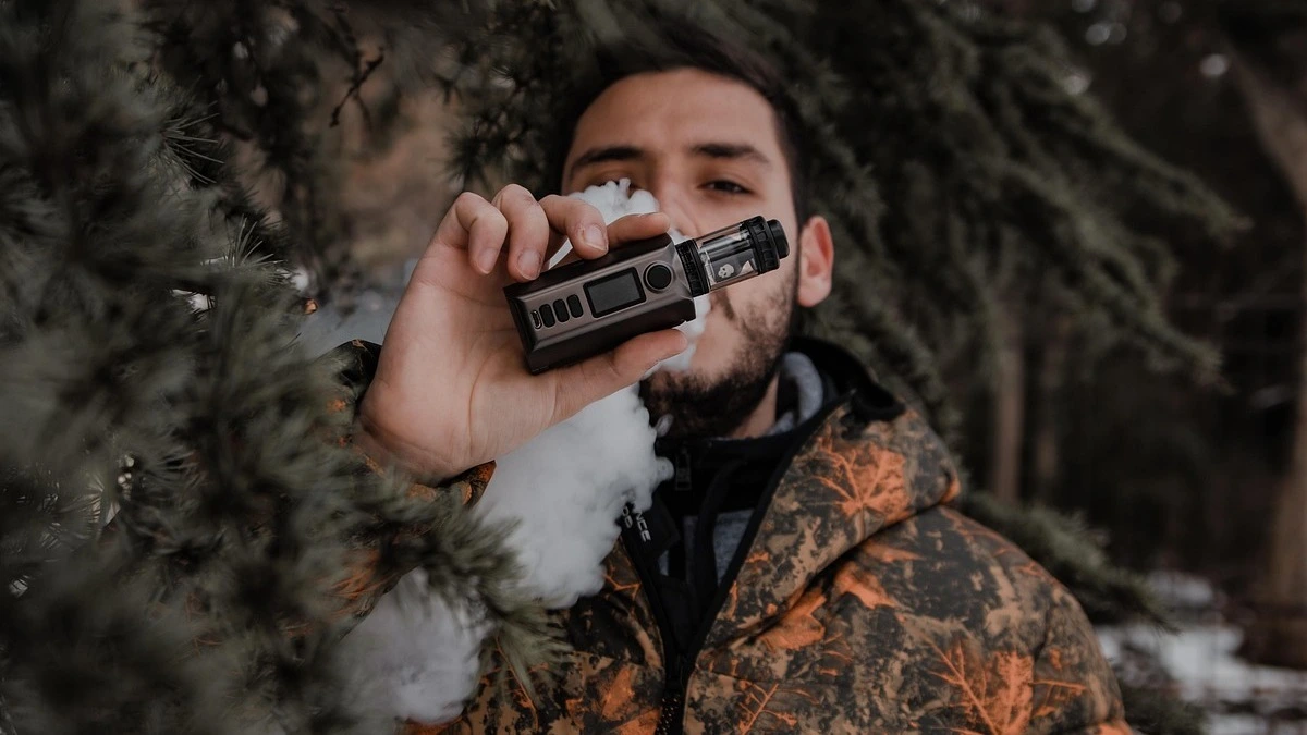 Person holding a disposable vape with a brain illustration showing dopamine pathways, representing how nicotine rapidly affects the brain and causes addiction.