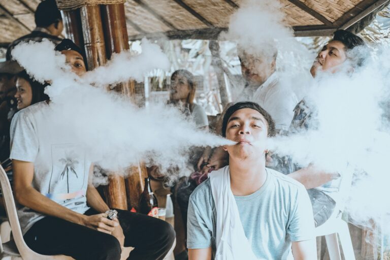 Teenager holding a vape device with a brain development illustration showing nicotine's effects on the adolescent brain