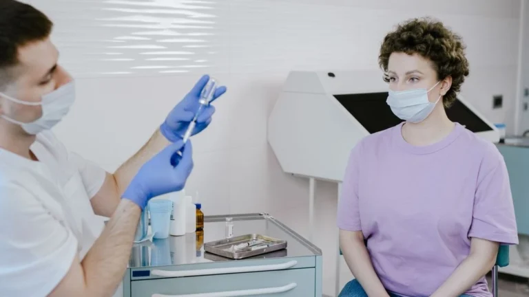 Patient watching a healthcare worker open a sealed sterile syringe before an injection