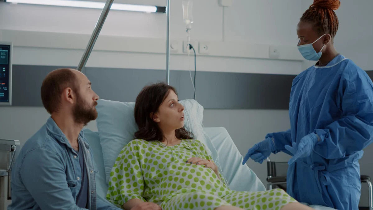 Pregnant woman discussing VBAC and normal delivery after C-section with her doctor